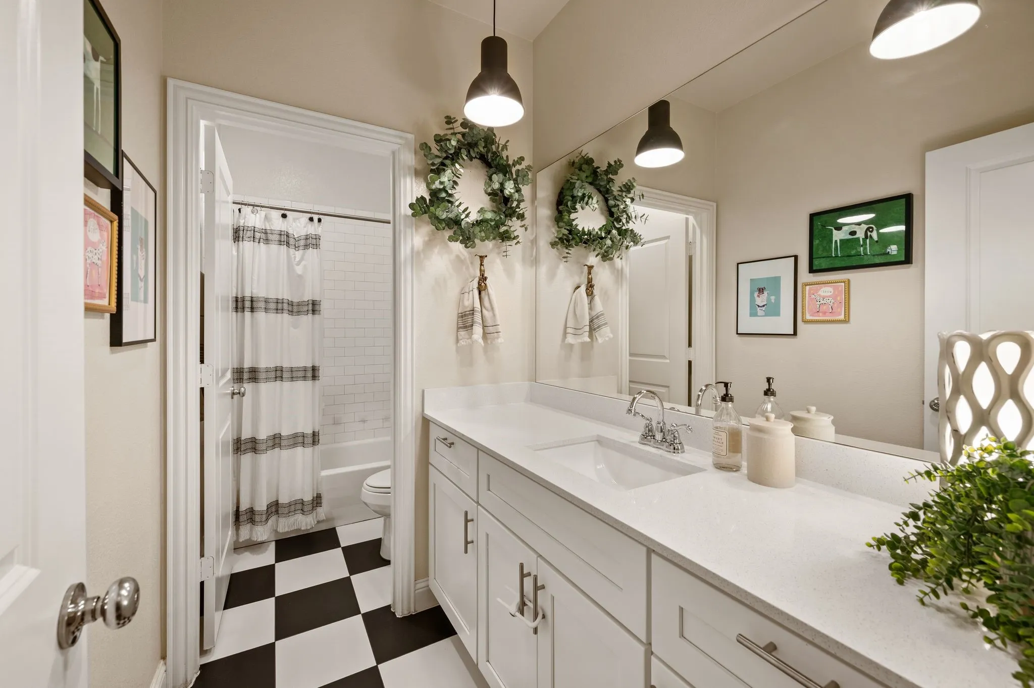 Spa-inspired bathroom featuring a dual-sink vanity with white cabinetry and white quartz countertops, polished with abundant storage and updated lighting!