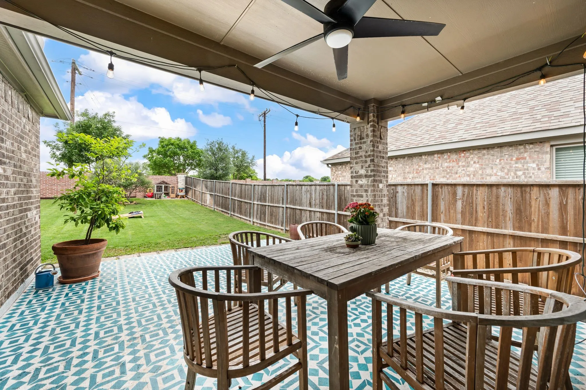 Covered patio featuring a ceiling fan and  fun patterned floor.  It is an extend patio and a nice large shaded area!