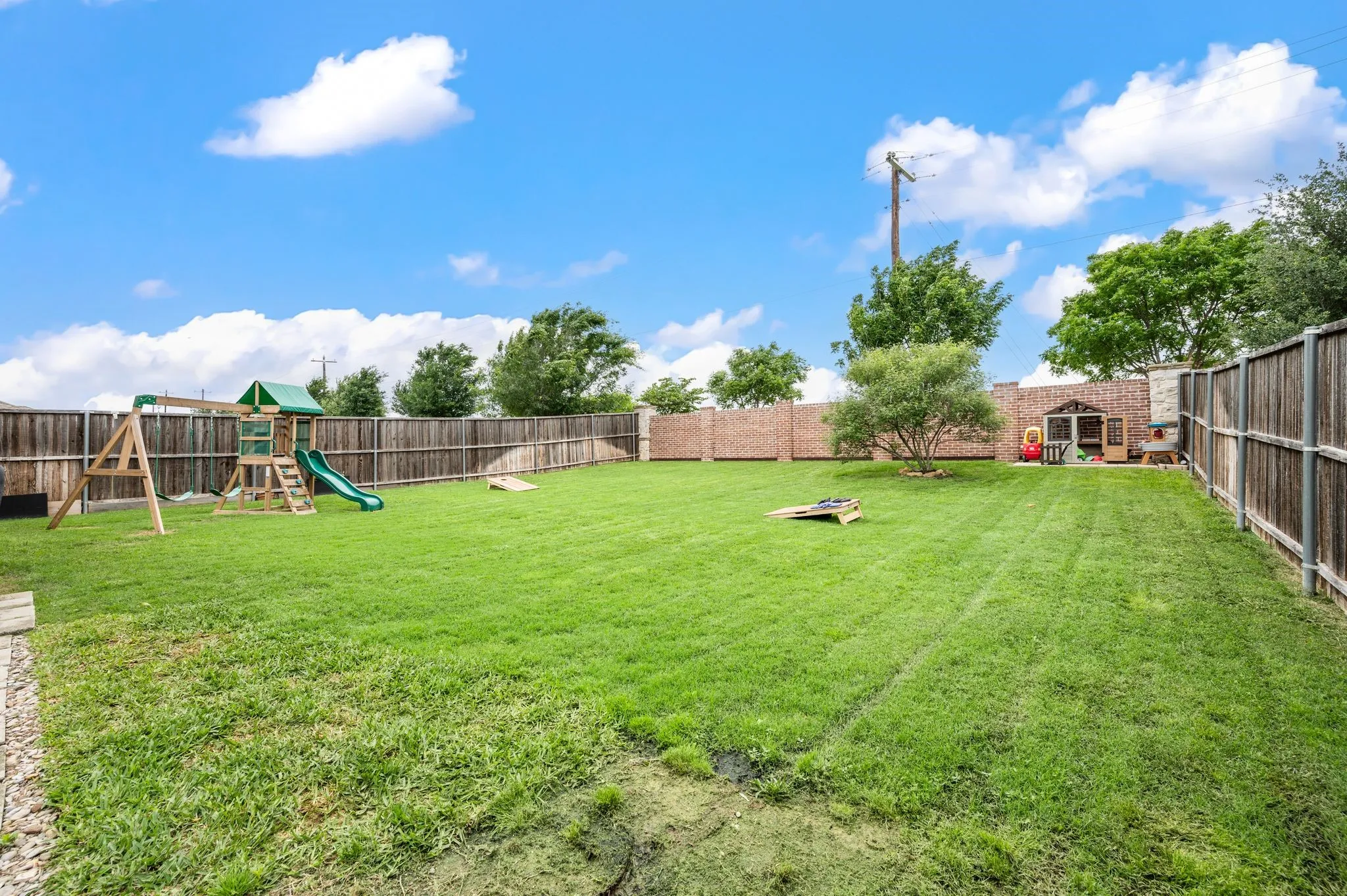 Expansive backyard featuring a lush lawn, wood privacy fencing, and a partial brick perimeter wall...this backyard has space for a pool and then some!!! Come see it in person!