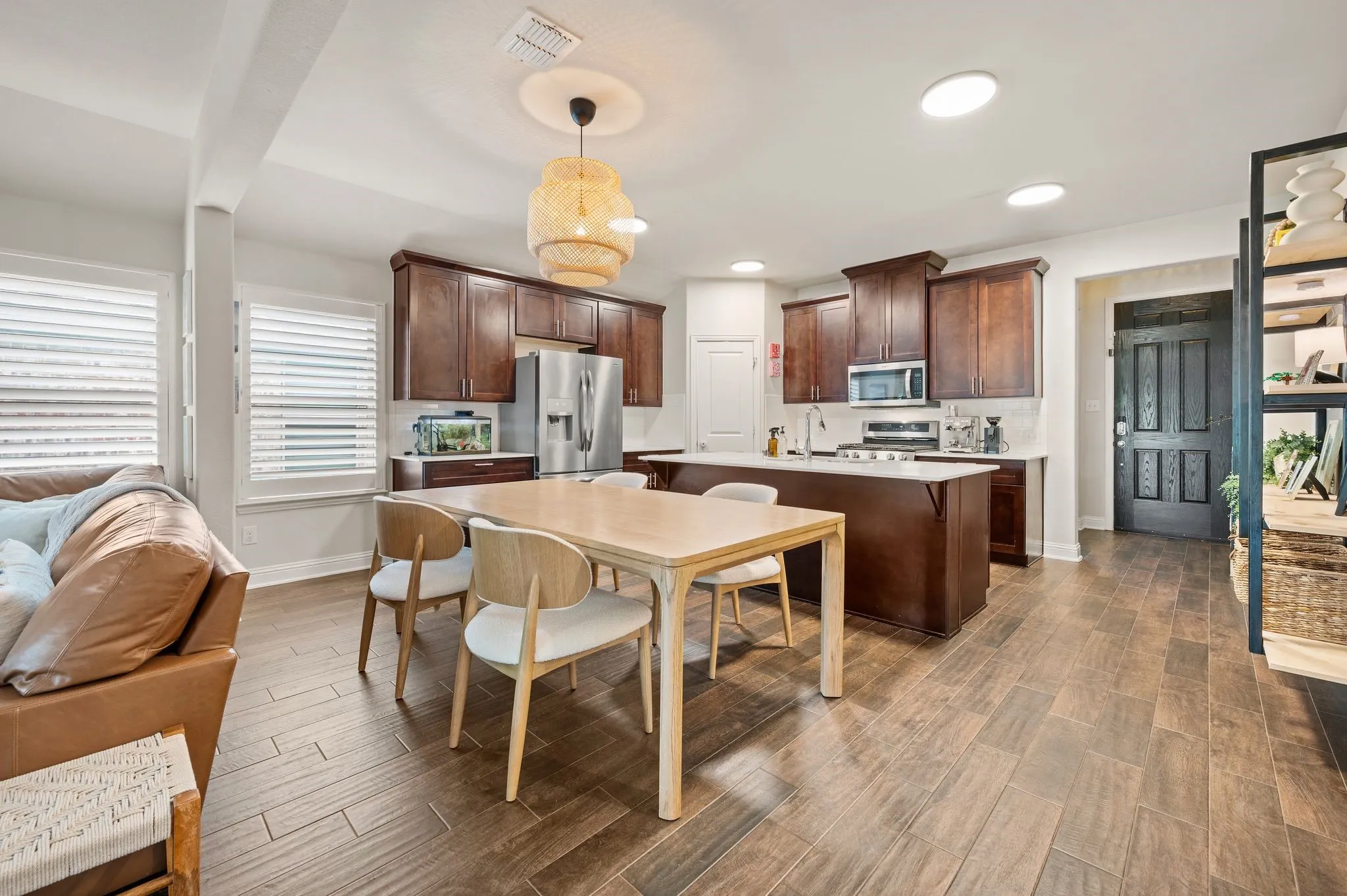 Open-concept dining/kitchen with  recessed lighting, and a kitchen island with seating and updated chandelier!