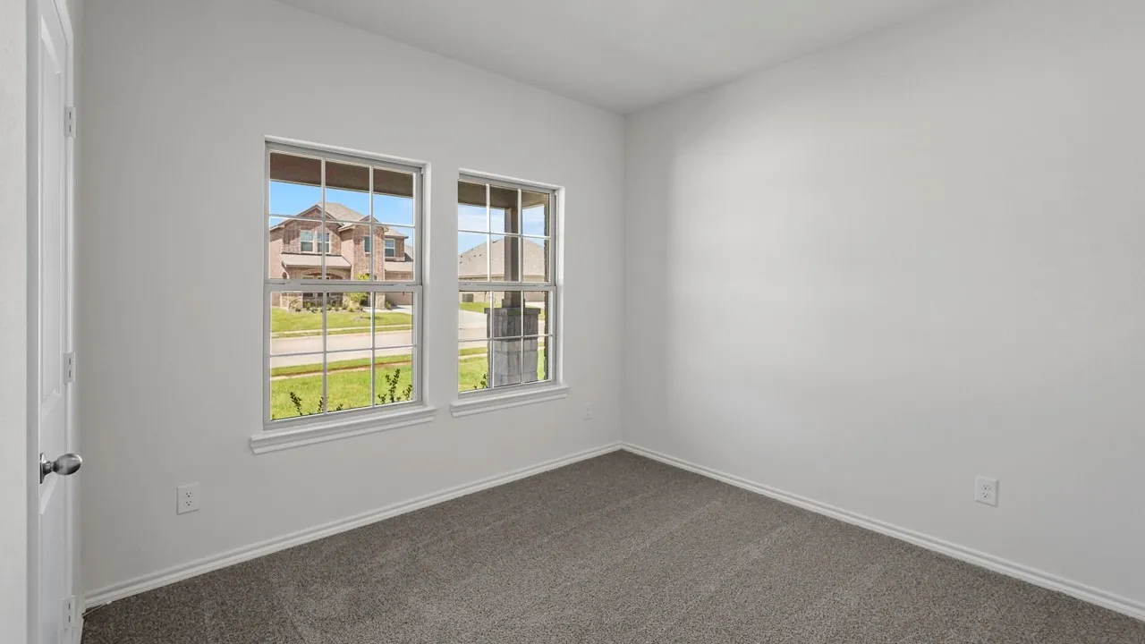 White painted walls, two large windows, gray carpet, and white trim