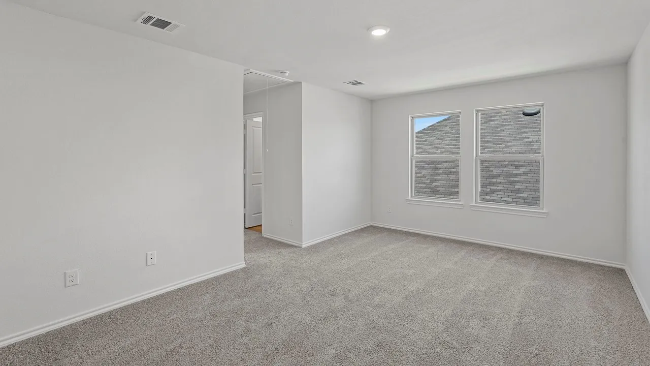 Neutral gray carpeting with white trim, two double-hung windows, and ceiling-mounted lighting