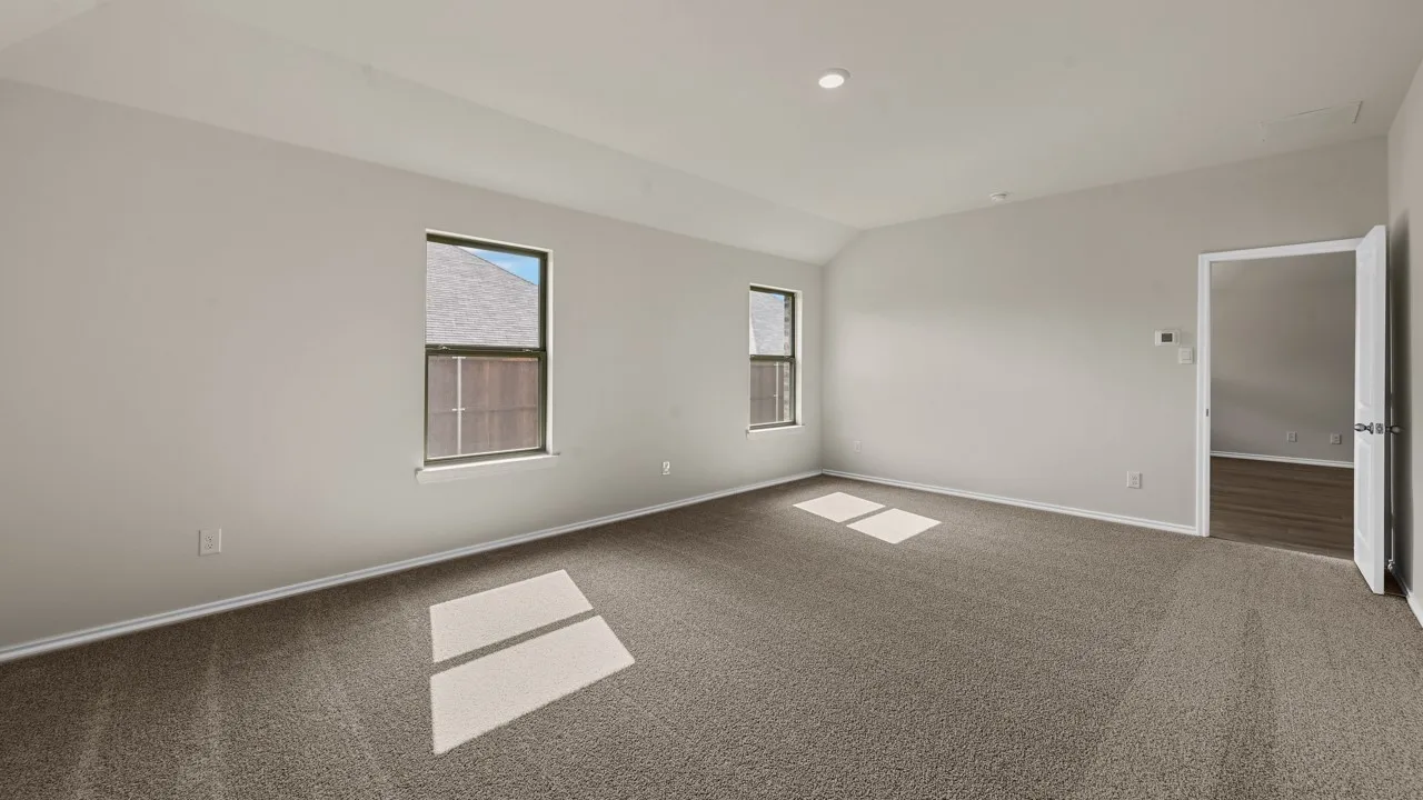 Vaulted ceiling with recessed lighting, two windows with dark frames, light gray painted walls, and textured carpet flooring