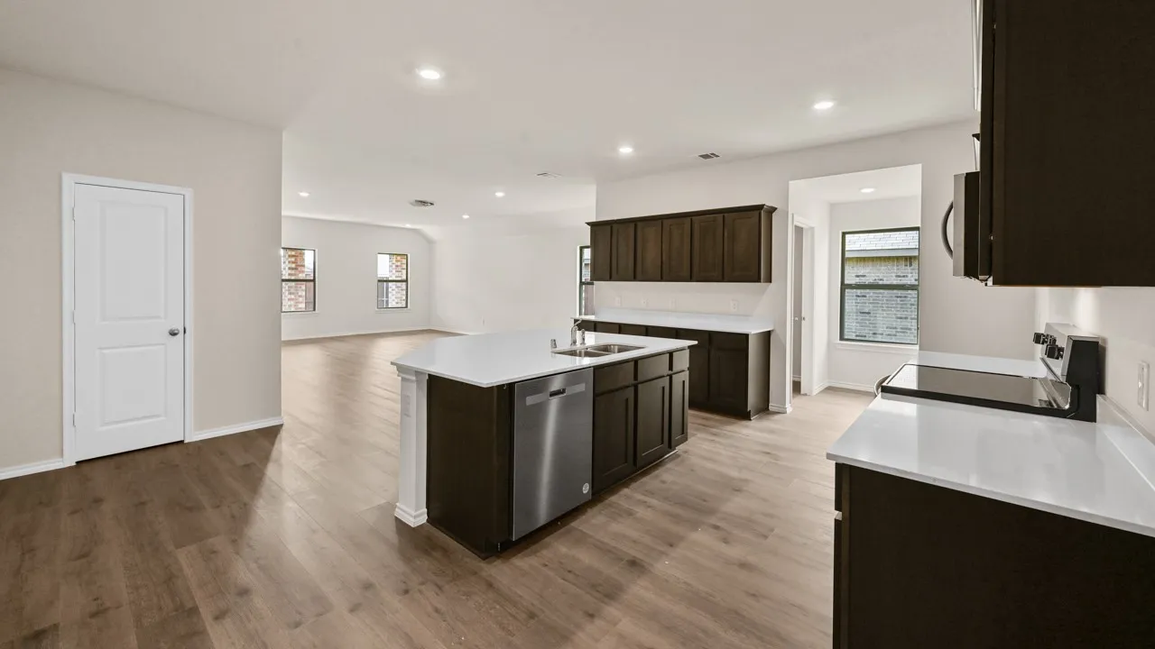 Open-concept living area featuring wood-finish flooring, recessed lighting, dark wood cabinetry, and white countertops