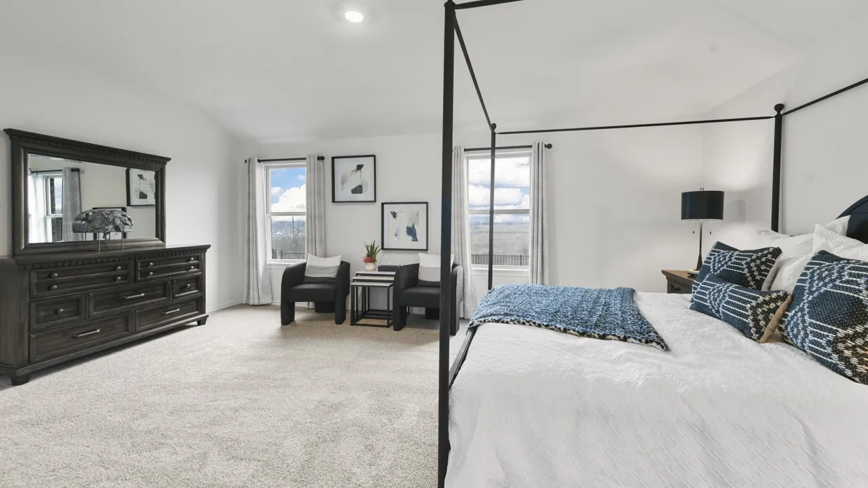 Bright bedroom featuring light-colored carpeting, multiple windows providing natural light, and recessed ceiling lighting