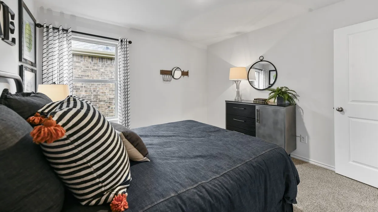 Spacious room featuring neutral carpet flooring, a large window, a white interior door, and light-toned walls