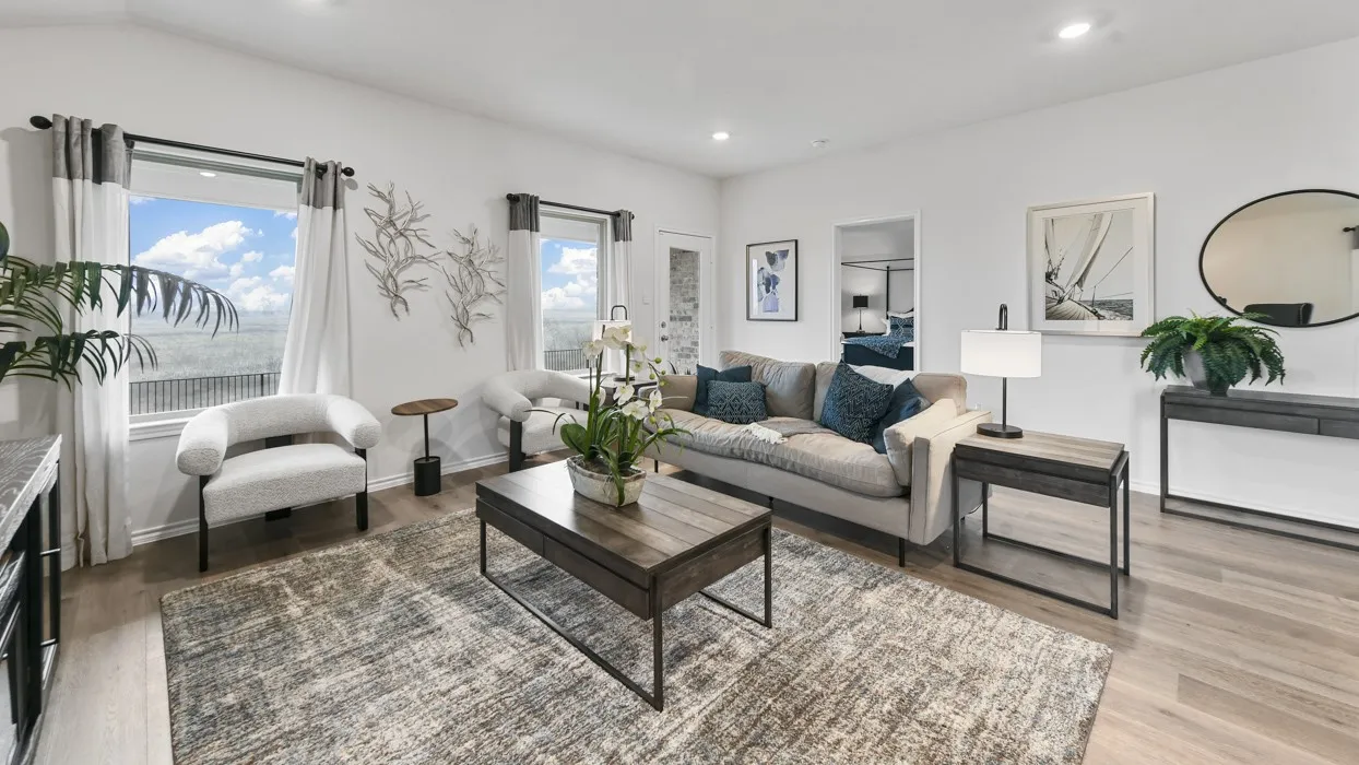Spacious interior featuring wood-finish flooring, recessed lighting, white walls, large windows, and a built-in console table