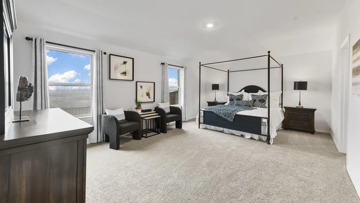 Spacious room featuring light-colored carpeting, multiple windows with white trim, and recessed lighting