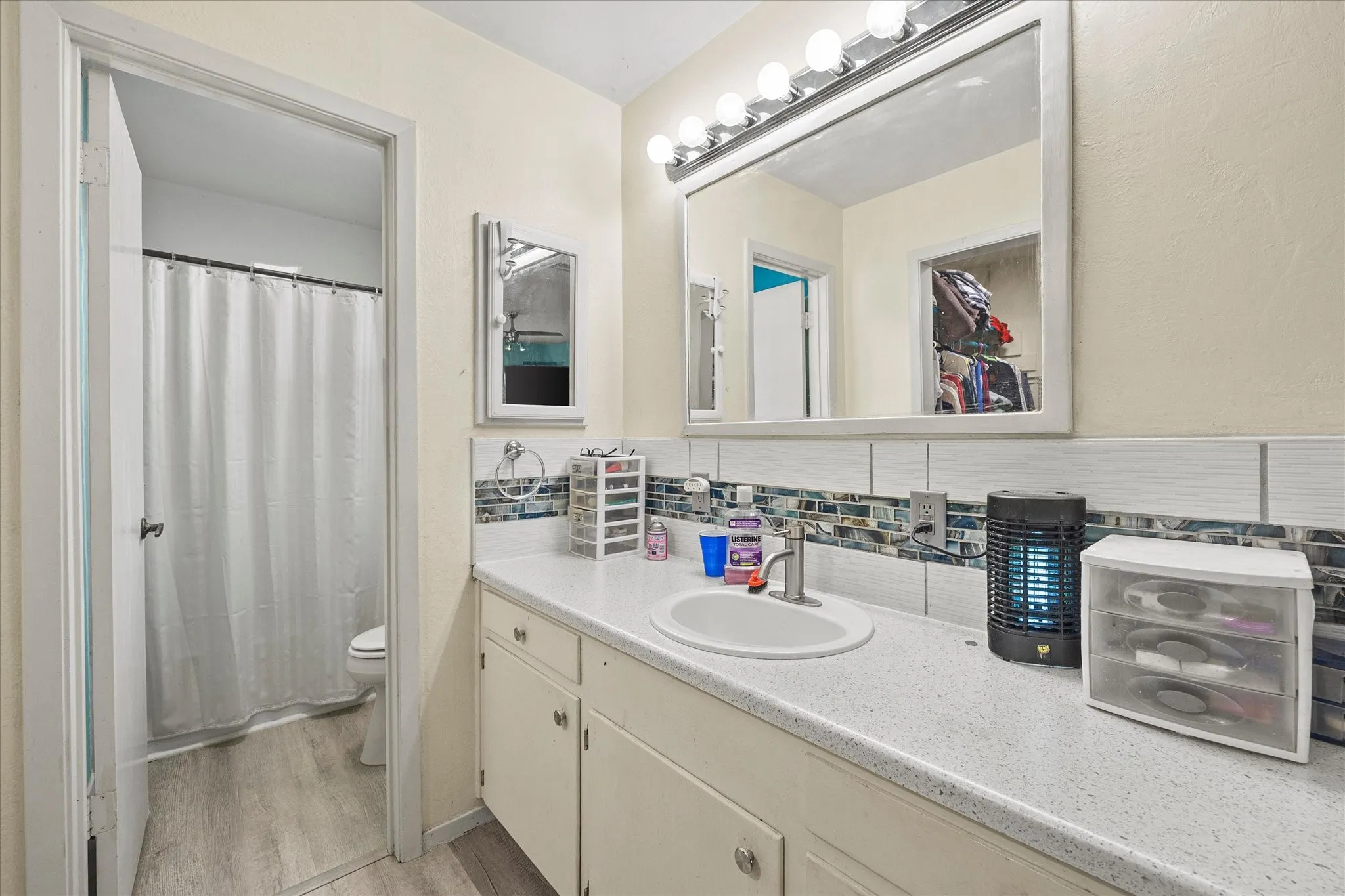 Vanity with integrated sink, light-toned countertop, and lower cabinetry