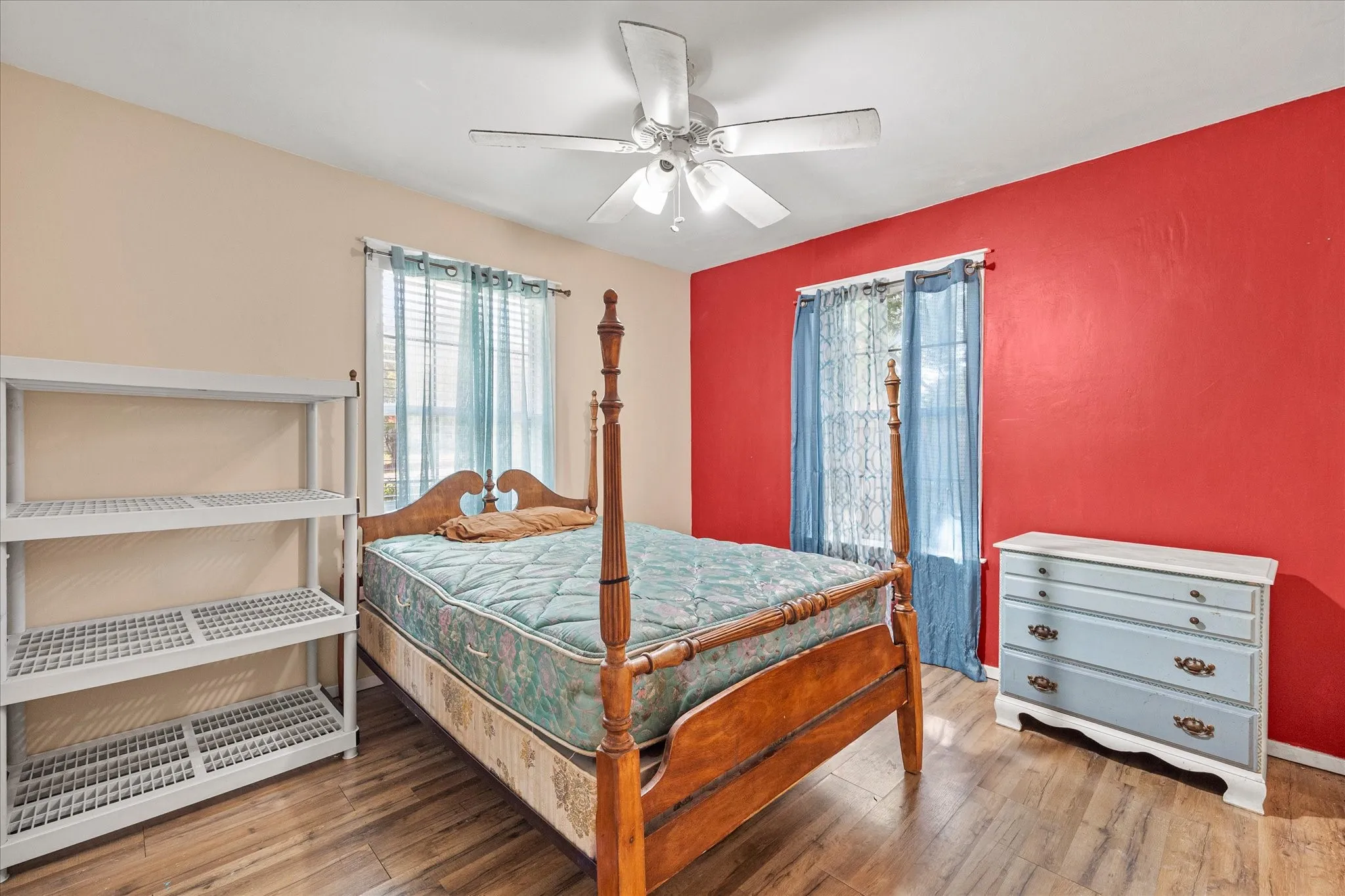 Wood-finish flooring, ceiling fan, and window with blinds