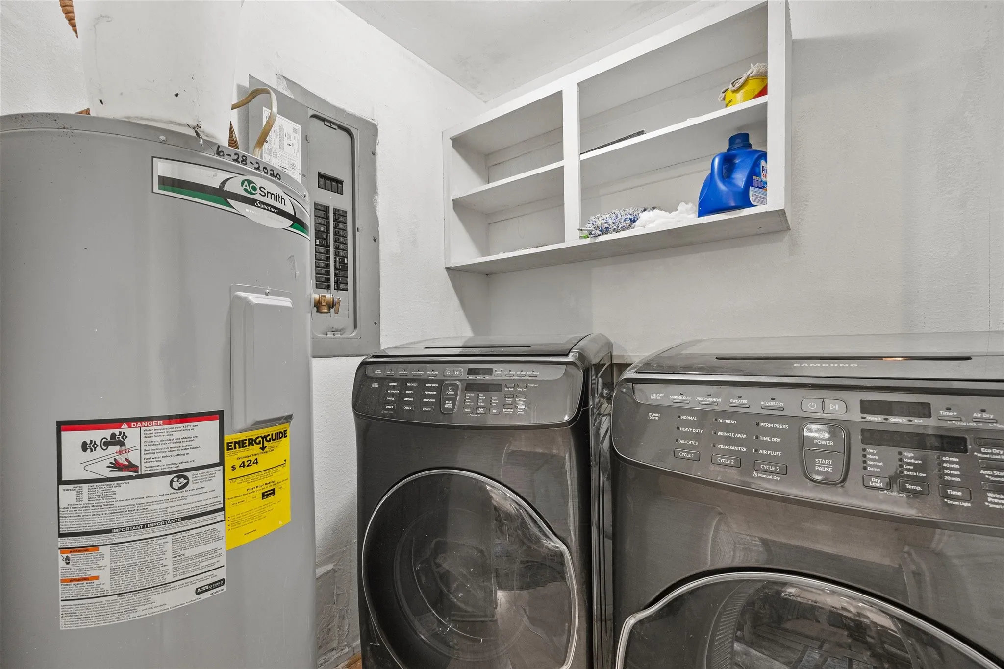 Utility area featuring a water heater, electrical panel, and built-in shelving