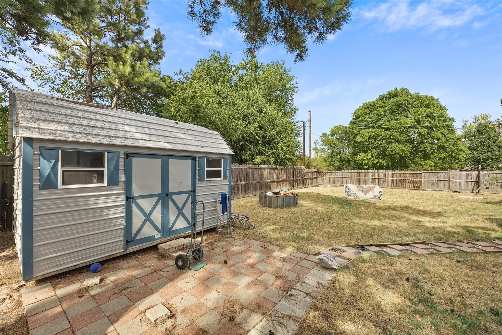 Detached storage shed with dual-pane windows, double doors, and a shingled roof