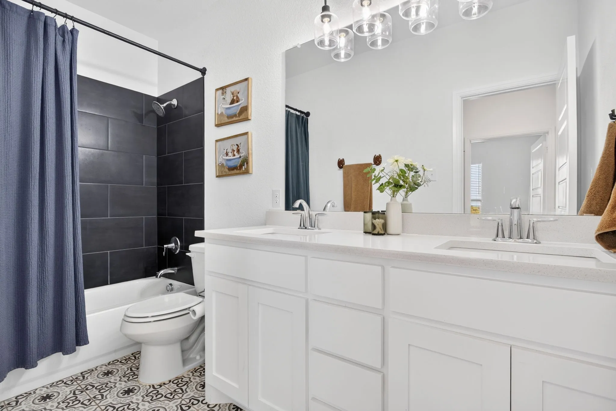 The hall bath has darling tile floors, dual sinks, and another nicely tiled tub-shower combo.