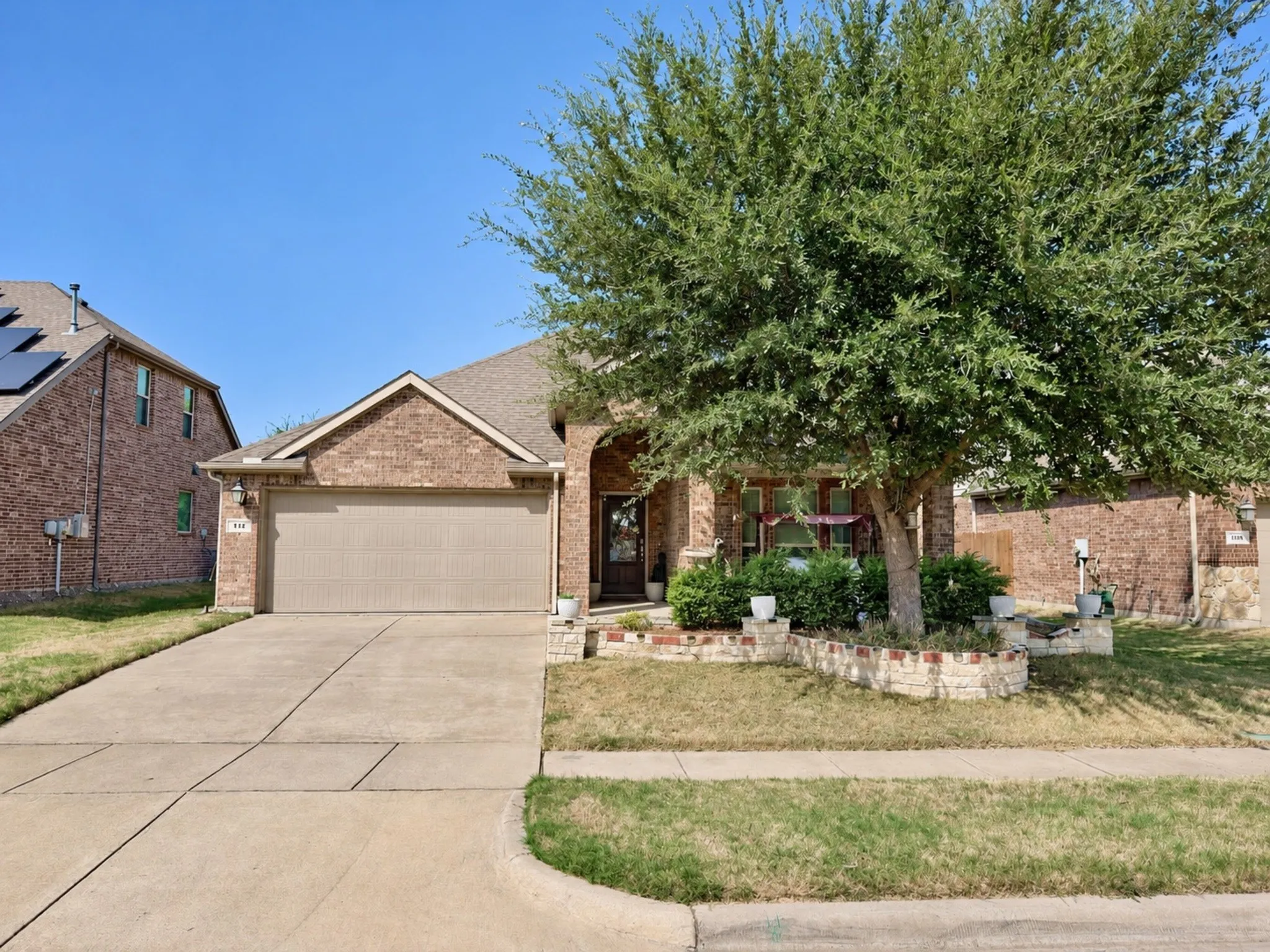 Brick exterior with an arched entry and an attached two-car garage