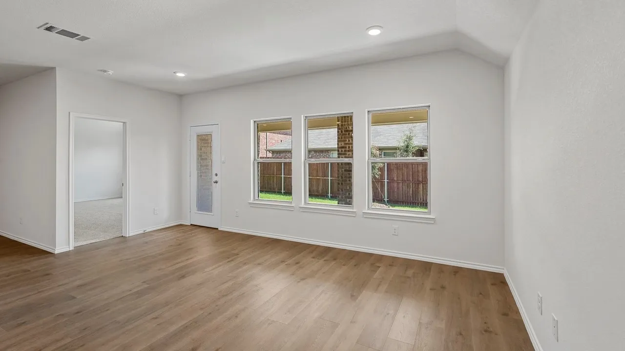 Wood-finish flooring, recessed lighting, white walls, multiple windows, and a patio door