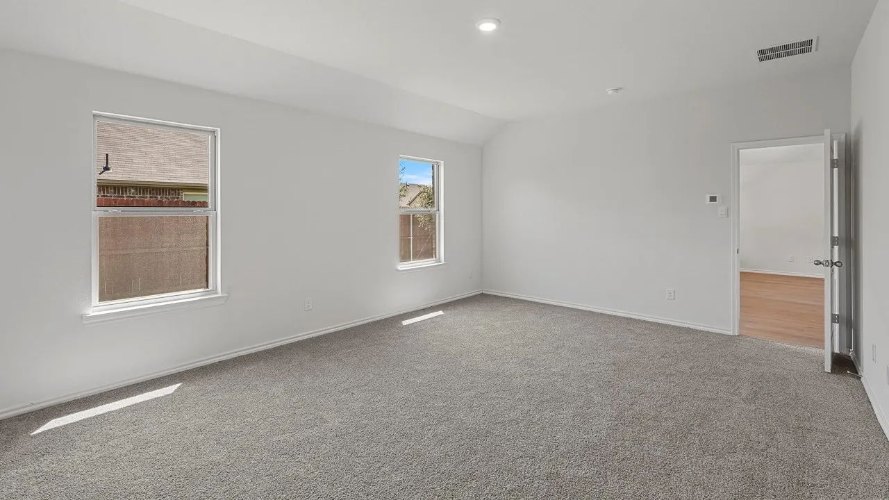 Spacious room featuring carpeting, multiple windows, recessed lighting, and a vaulted ceiling