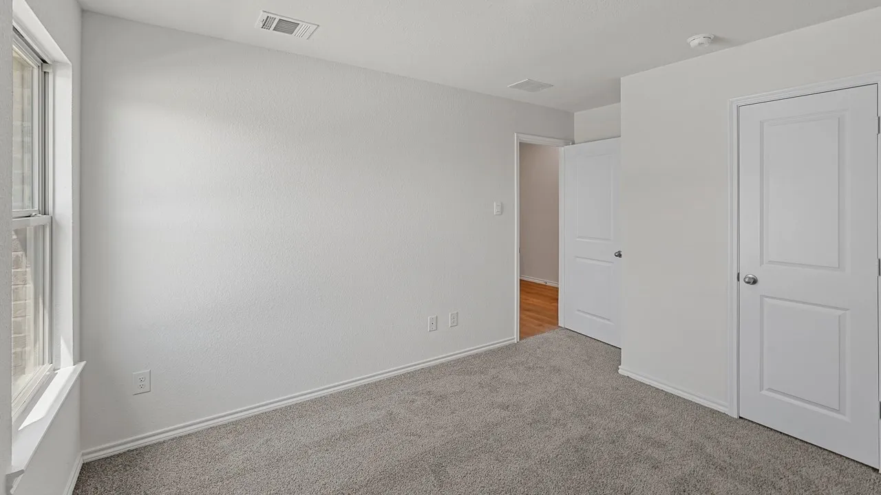 Neutral wall paint, gray carpet flooring, white trim, dual pane window, and panel doors