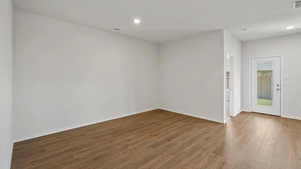 Recessed ceiling lighting, wood-finish flooring, white walls, and a glass-paneled exterior door