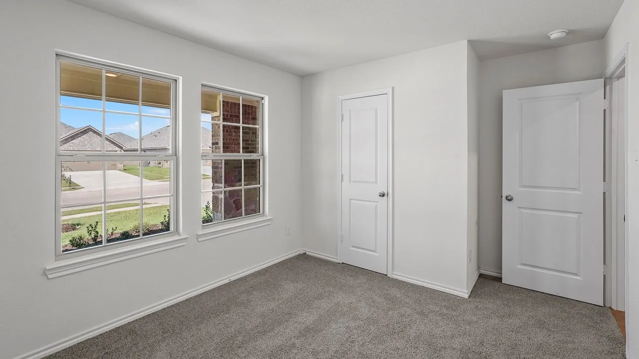 Plush carpet flooring, white painted walls, and white trim work