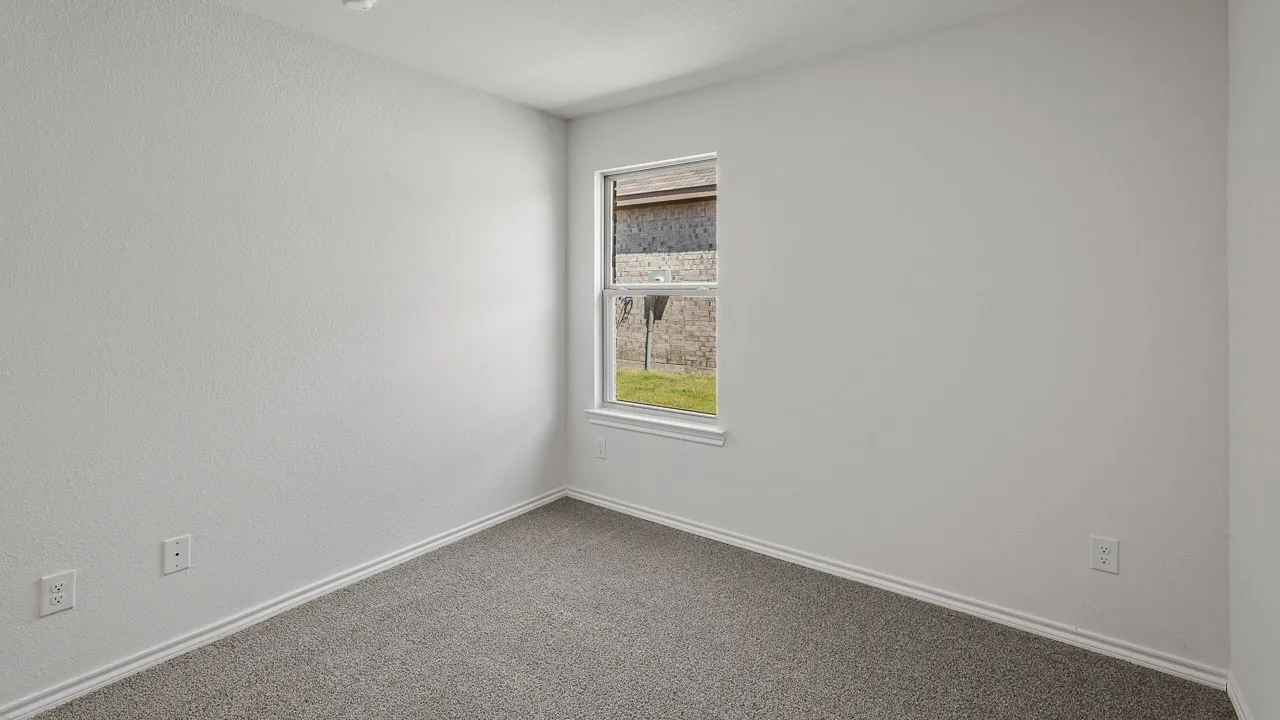 Neutral wall color with textured finish, light grey carpet, white trim, and a double-hung window
