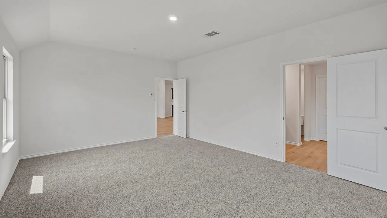 Spacious room featuring vaulted ceilings, recessed lighting, neutral wall tones, and plush carpet flooring