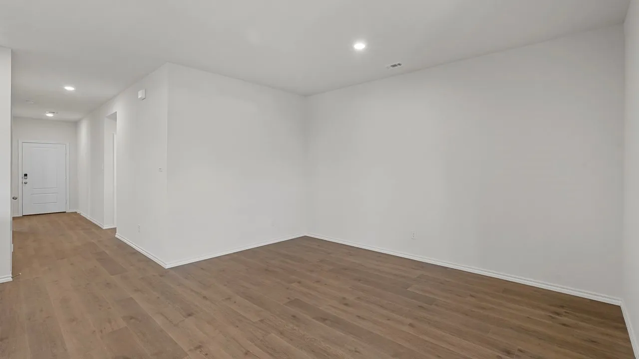 Wood-finish flooring, recessed lighting, white walls, and a white interior door