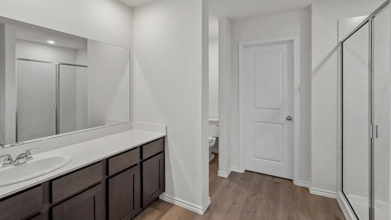 Vanity with undermount sink, dual handle faucet, and dark wood-finish cabinetry