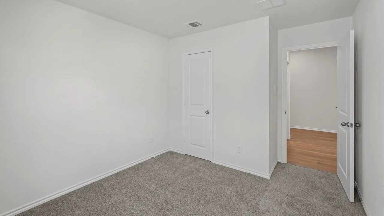 Neutral wall finishes, recessed ceiling light, and gray carpeting