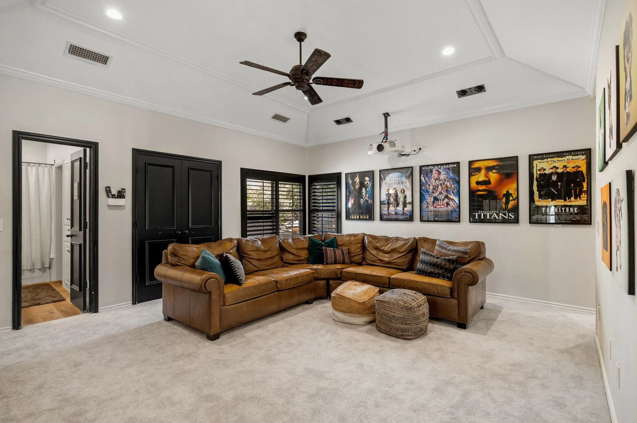 Spacious media room showcases a projector, built-in speakers & electronic screen to easily hide away when not in use.