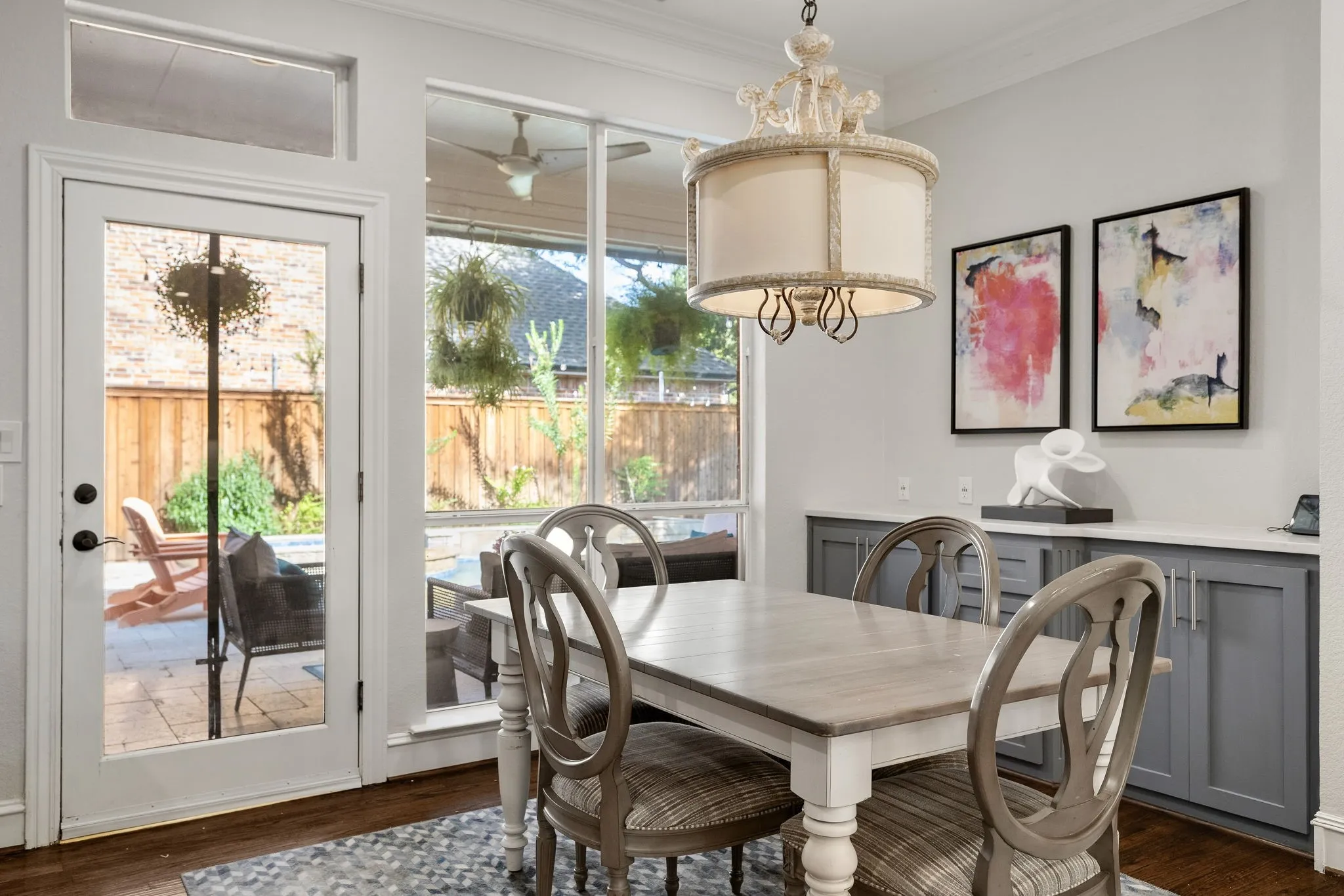 Pristine breakfast room with custom cabinetry, decorative lighting & views of the backyard oasis.
