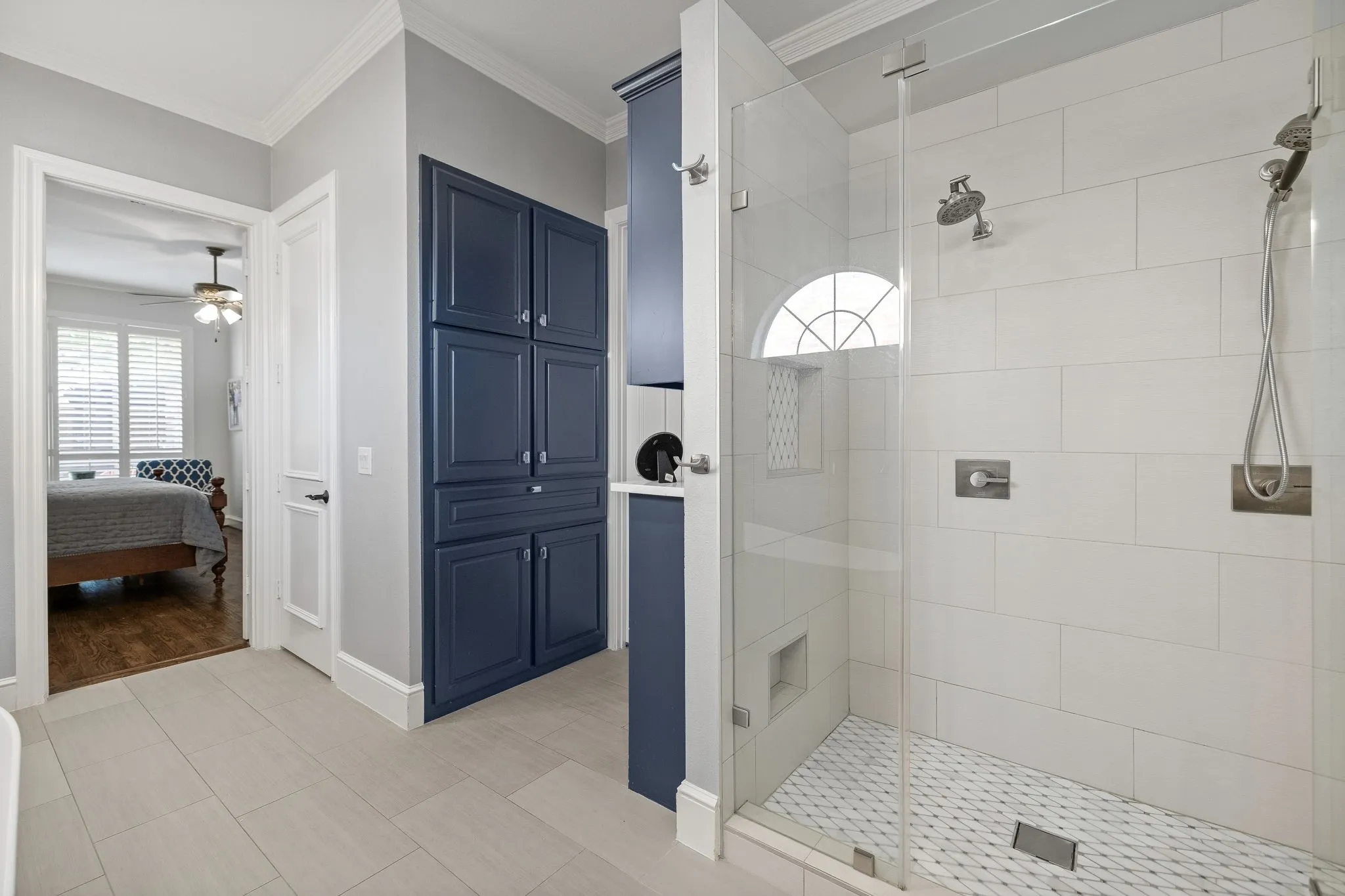 Additional storage in custom cabinetry leading to an extended walk-in closet with built-ins.