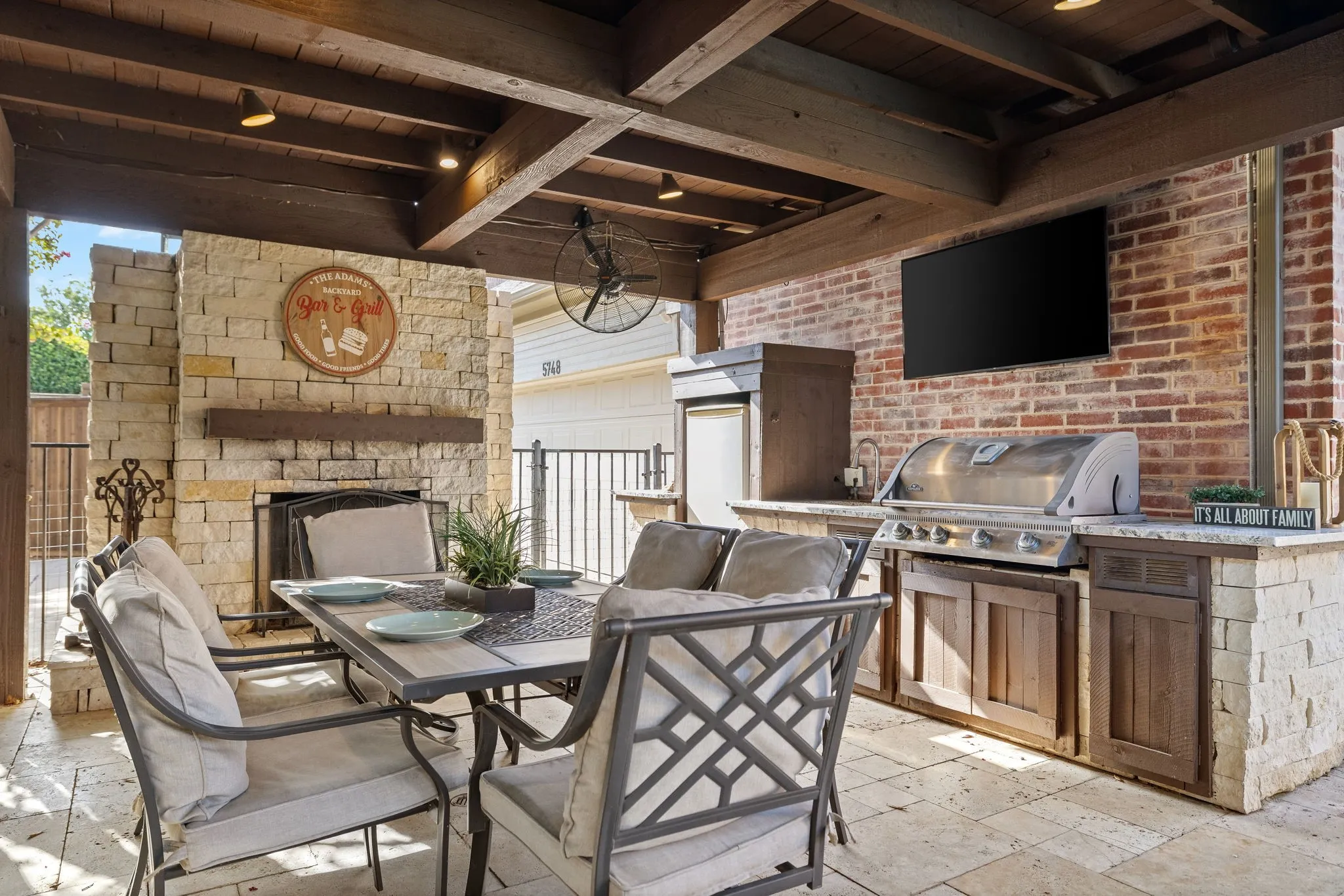 Outdoor living center with fireplace, grill, sink & fridge.