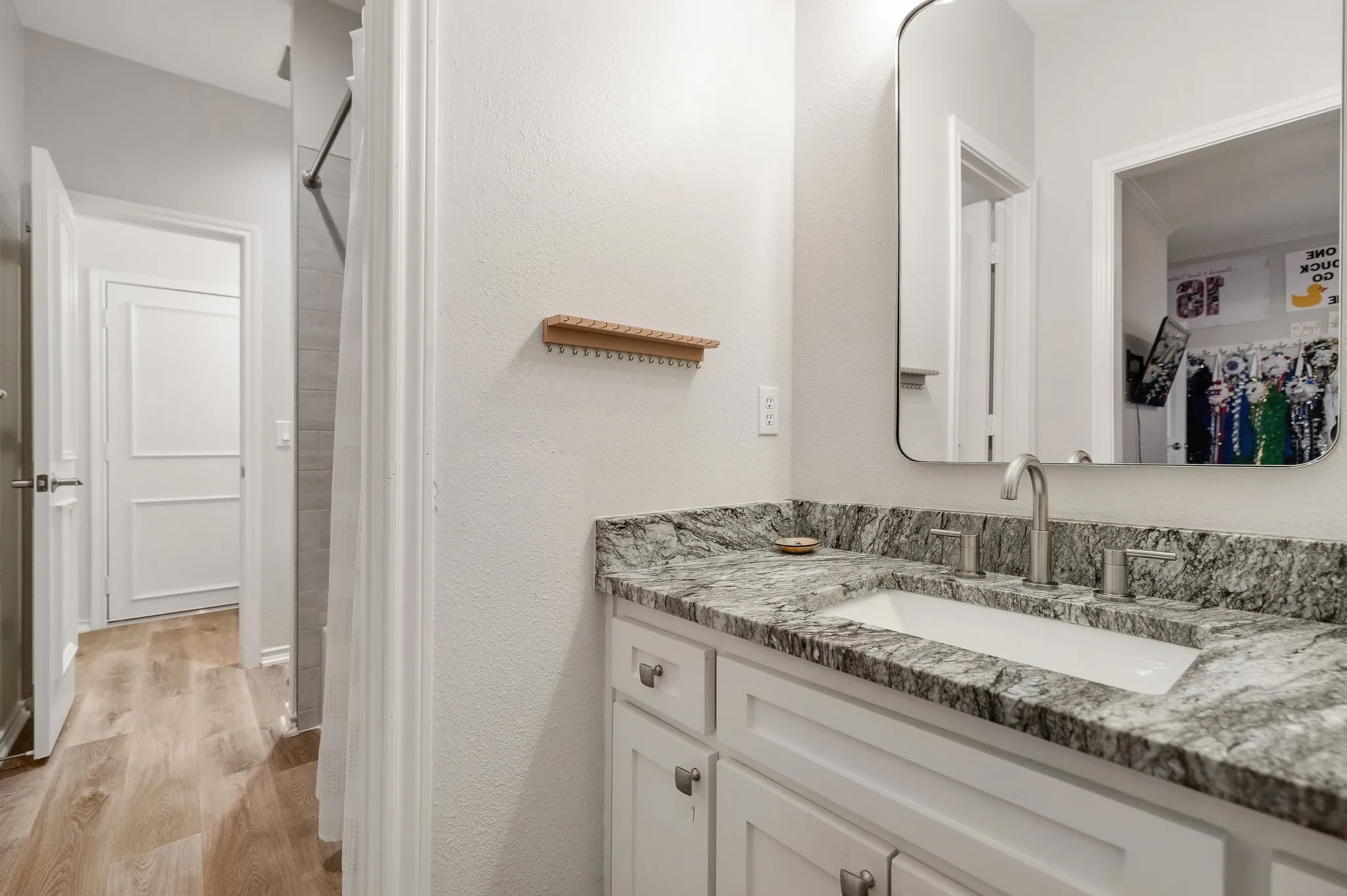 Jack & Jill bathroom with updated cabinetry, granite counters, flooring & shower tile.