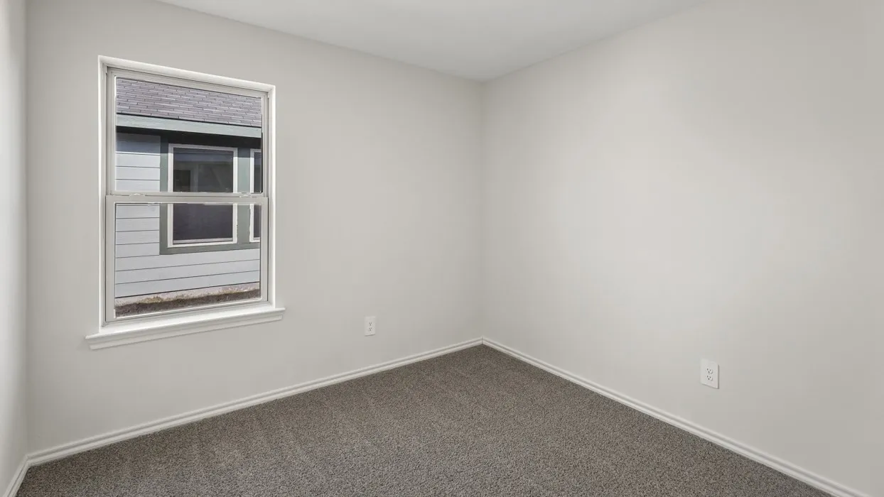 Neutral wall paint, gray carpeting, and a double-hung window