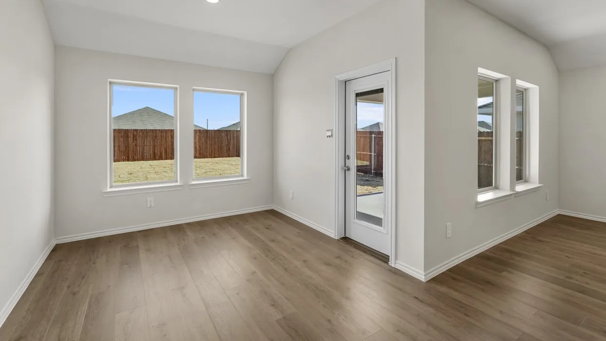 Wood-finish flooring throughout, multiple windows with white trim, recessed lighting, and a glass-paneled door