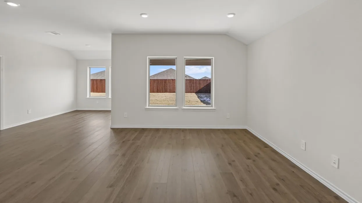 Spacious room featuring wood-finish flooring, recessed lighting, and multiple windows
