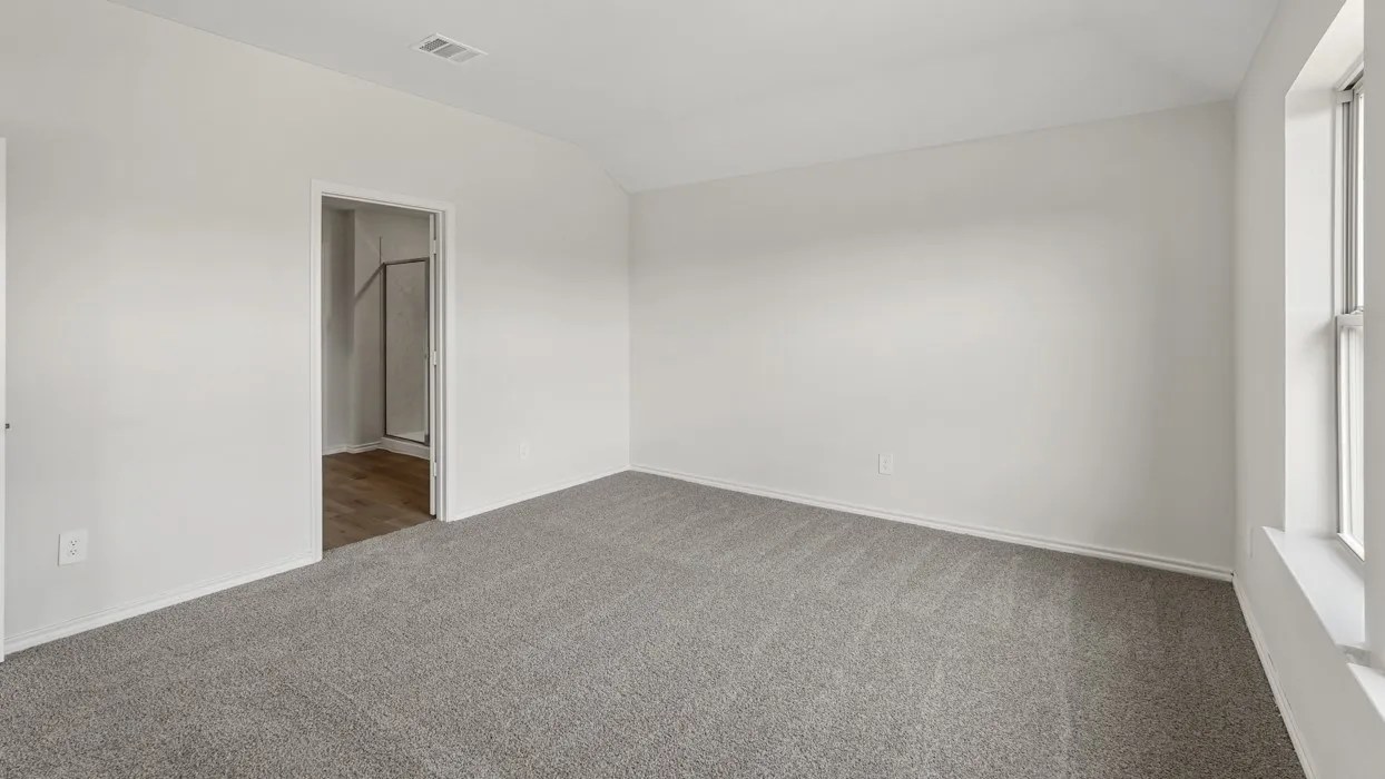 Neutral wall tones, vaulted ceiling, and carpeted flooring