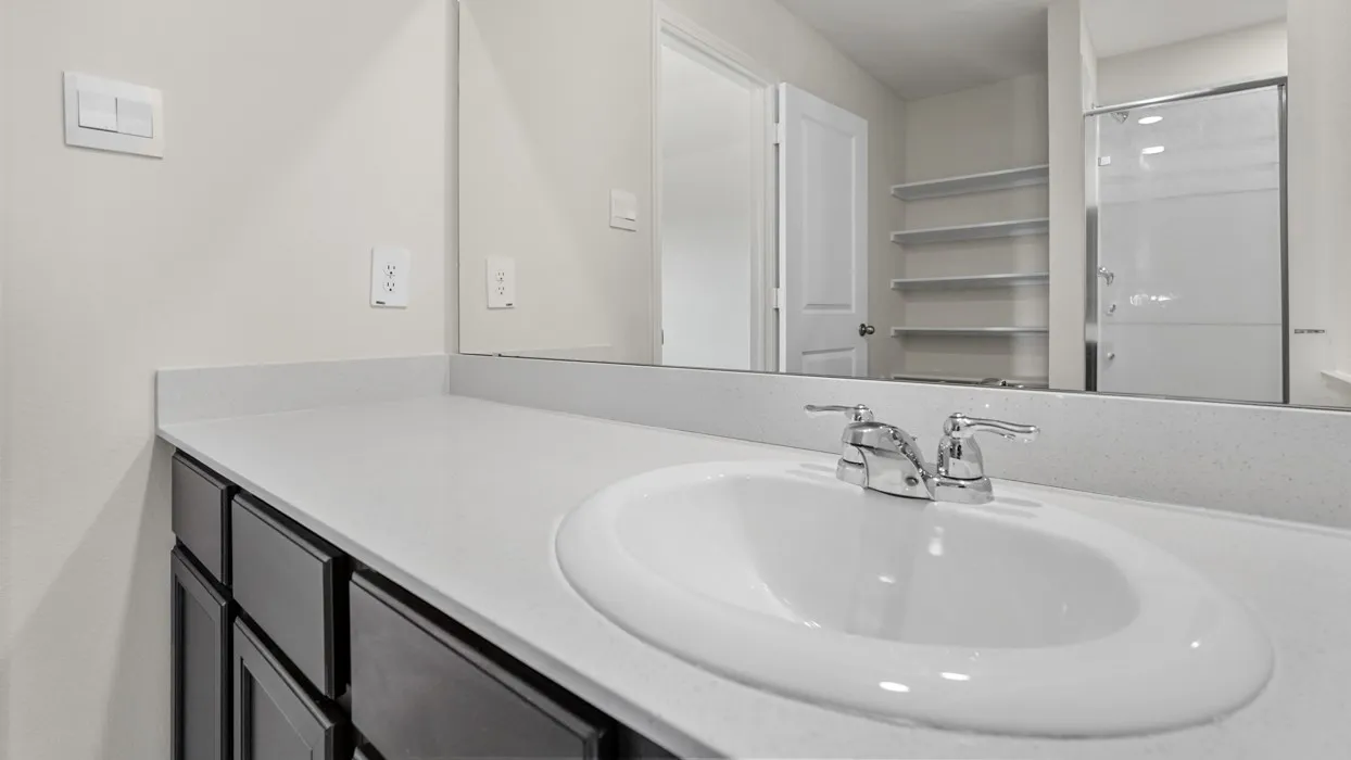 Vanity featuring an integrated sink, polished chrome faucet, and dark wood-finish cabinetry
