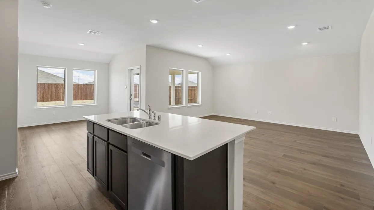 Kitchen island featuring a double-basin stainless steel sink, pull-down faucet, and integrated stainless steel dishwasher