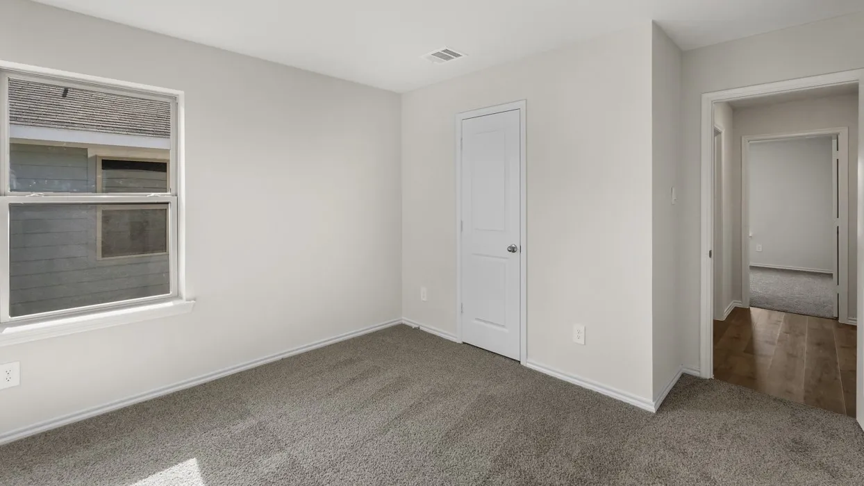 Neutral-toned room featuring light gray walls, plush gray carpeting, and white trim