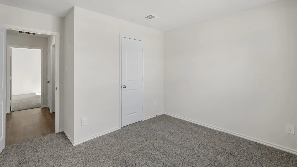 Neutral gray wall paint with white baseboards, gray carpet, and a white two-panel interior door
