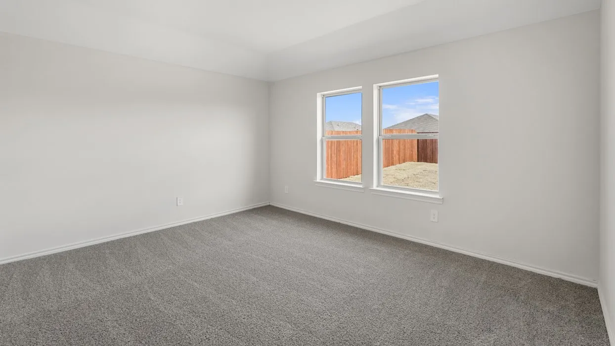 Bright room featuring two windows, light gray carpet, white walls, and a tray ceiling