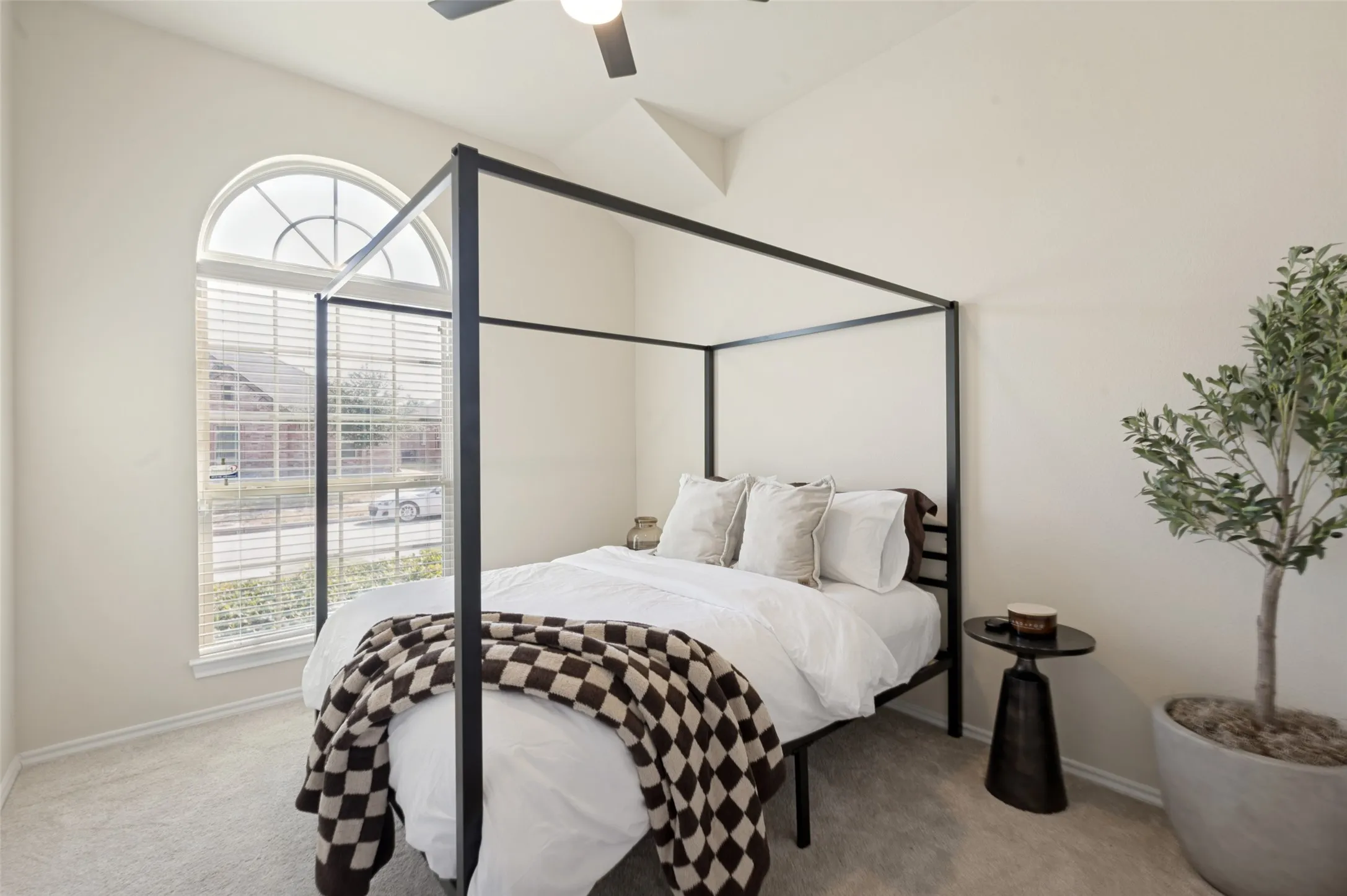 Vaulted ceiling with a ceiling fan, arched transom window, window blinds, and light-toned wall paint