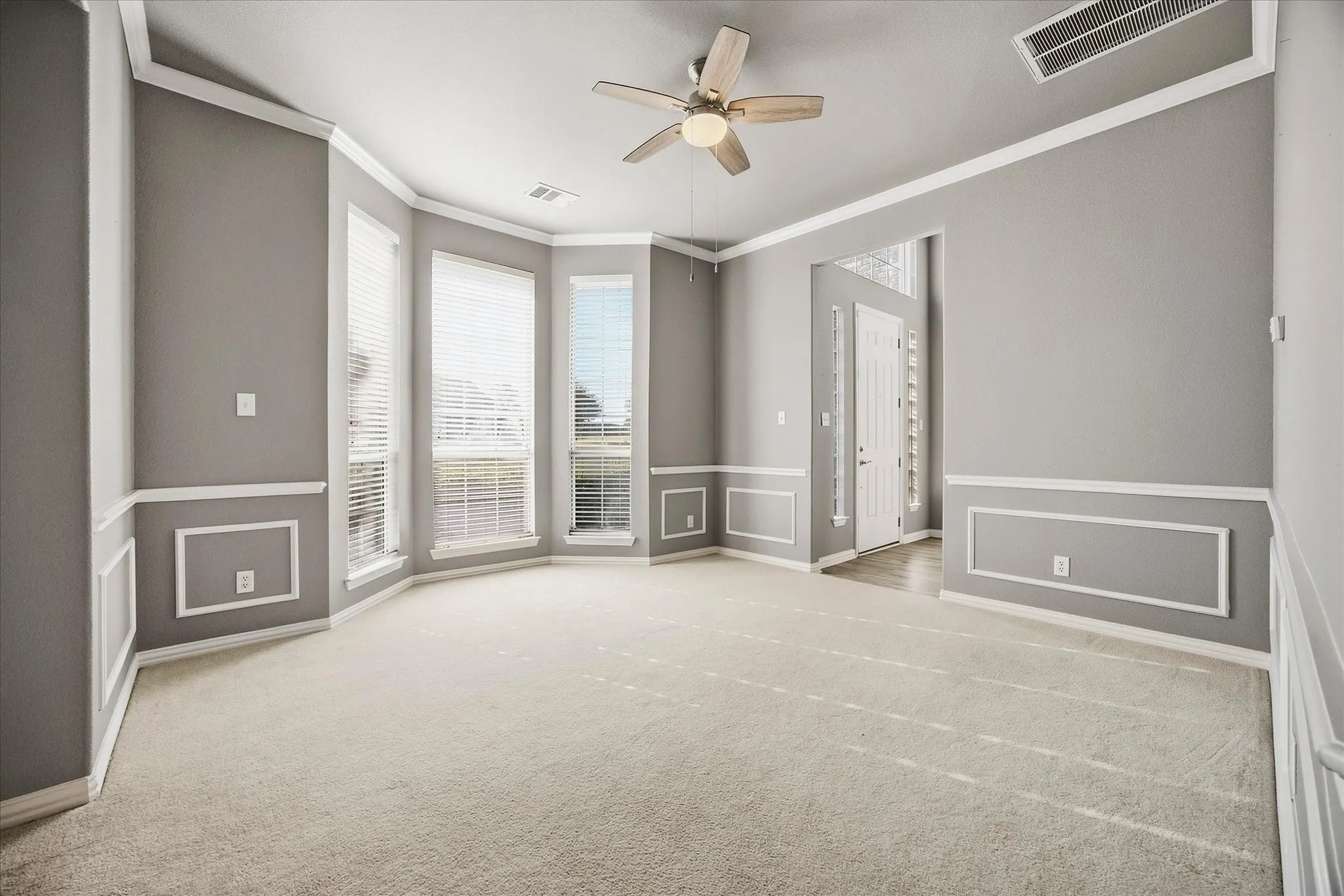 Spacious living area includes floor to ceiling windows.