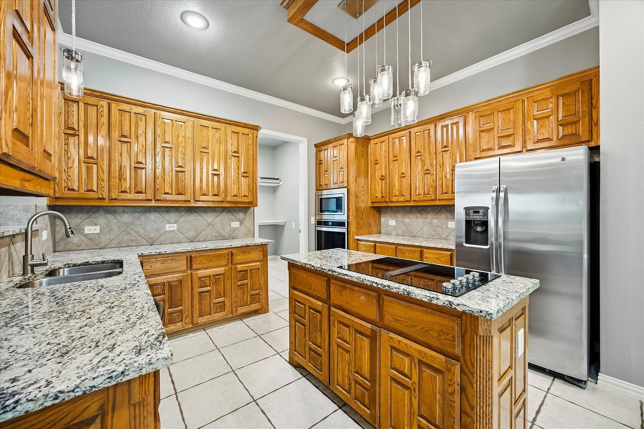 Updated kitchen includes tons of custom cabinetry, granite counter tops, center island, stainless steel appliances and spacious pantry.