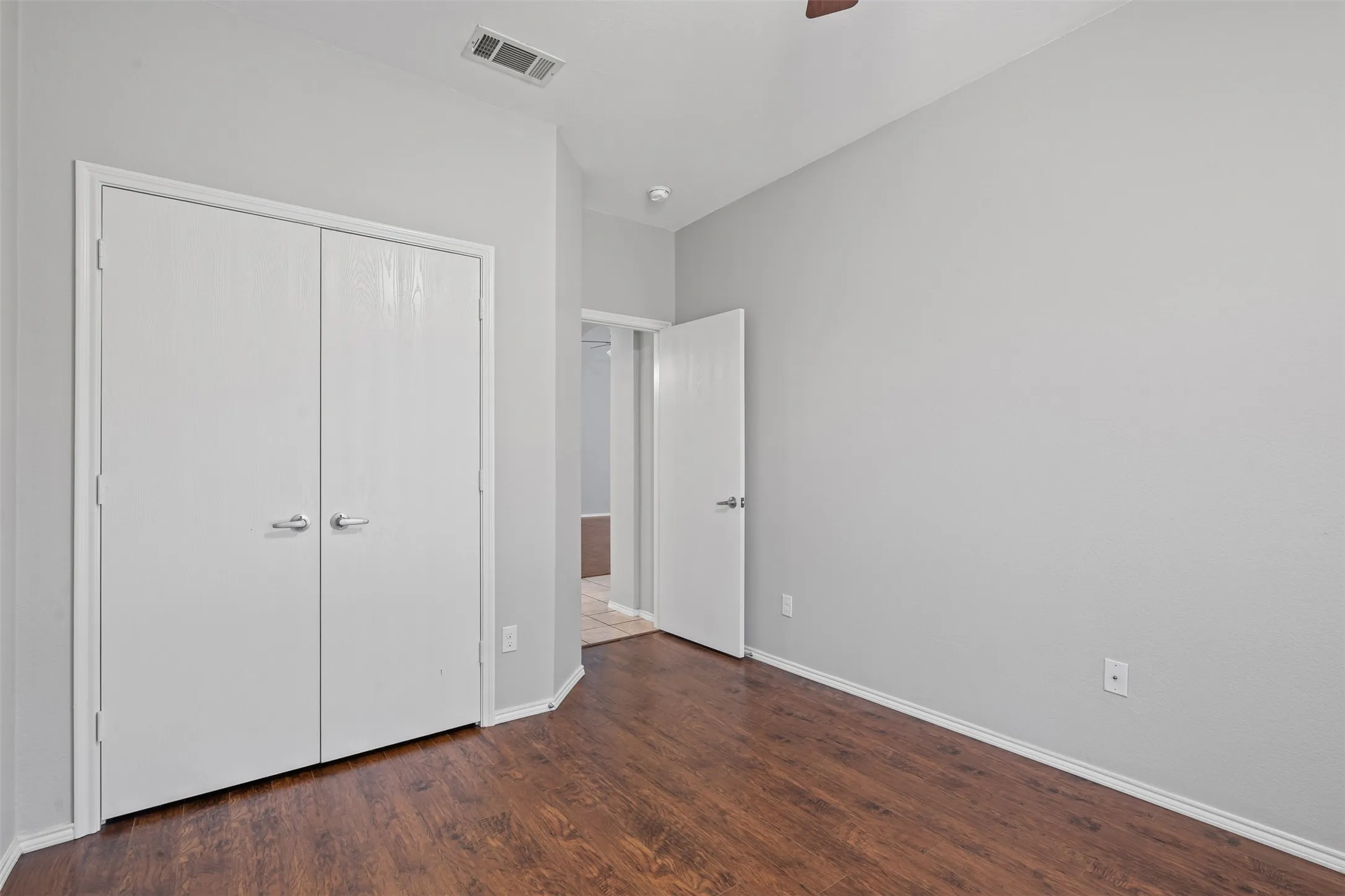 Wood-finish flooring, light gray wall paint, and white trim