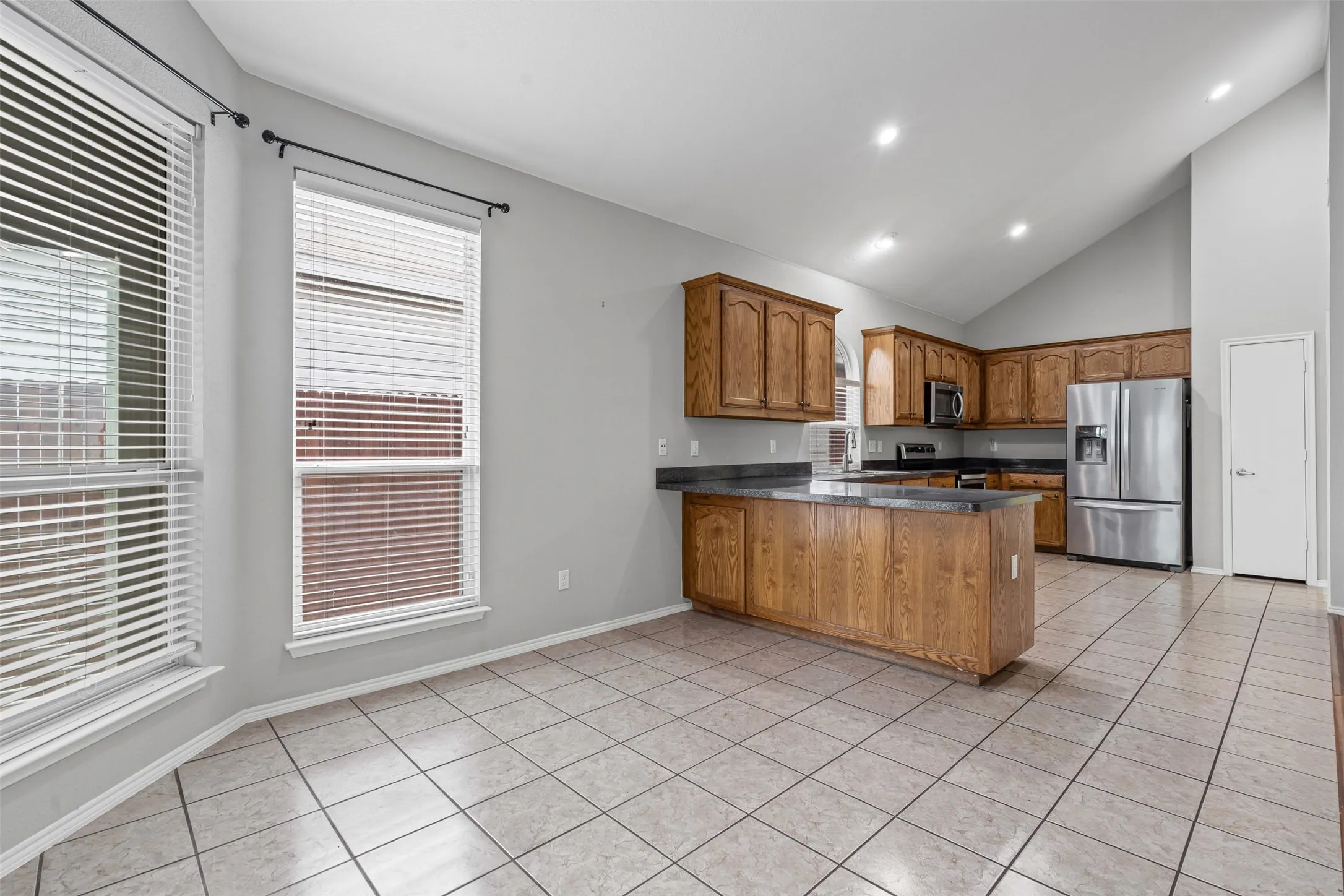 Kitchen featuring wood cabinetry, dark countertops, and stainless steel appliances