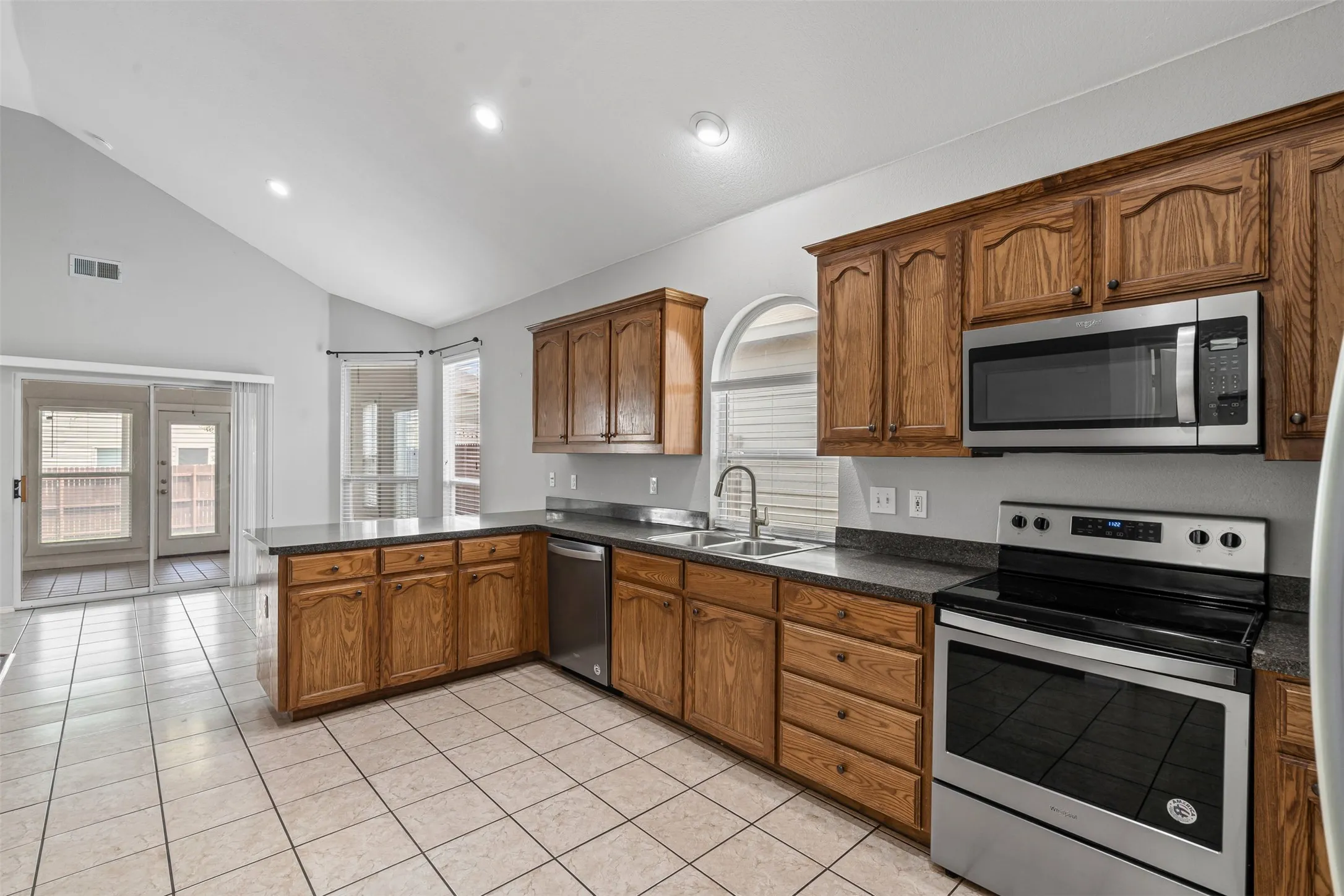 Kitchen featuring wood cabinetry, stainless steel appliances, and a tile floor