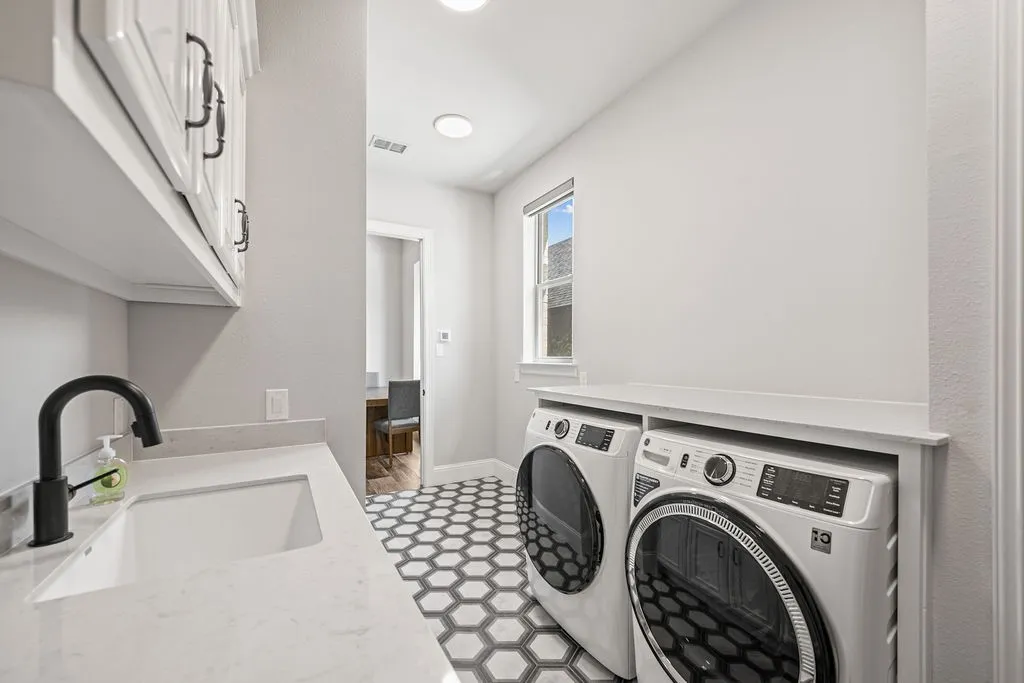 White shaker-style cabinetry with dark hardware, a single basin sink, and a matte black faucet