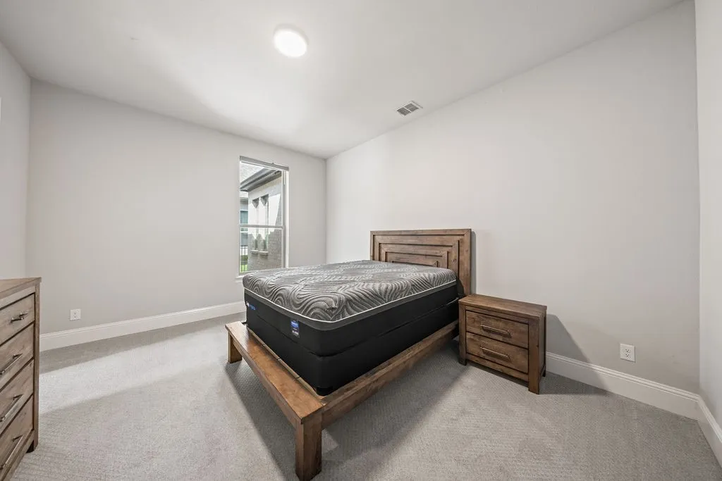Recessed ceiling light, neutral wall color, single window with exterior landscaping visible, light-toned carpeting, and white trim